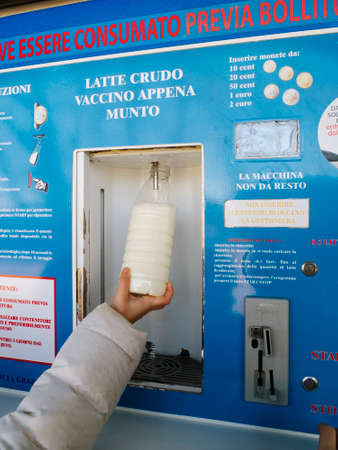 children take raw milk from a distributor positioned on a farmの写真素材