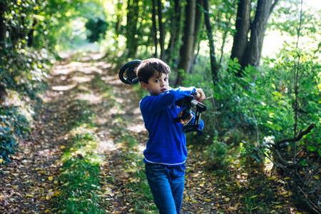 child with metal detector in the woods in springの写真素材