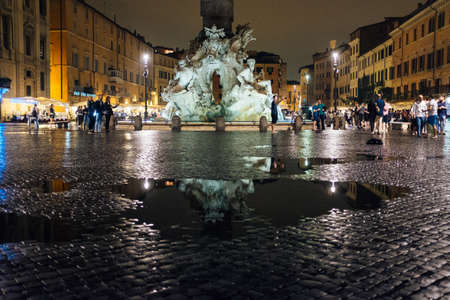 Rome-September 16, 2017-Piazza Navona on a rainy night tourists stroll in the square, many puddles reflectのeditorial素材