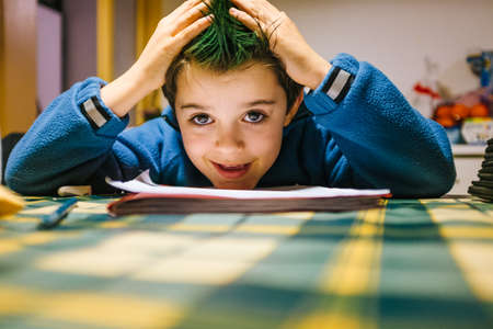portrait of 9 year old boy at home with crest of green colored hairの写真素材
