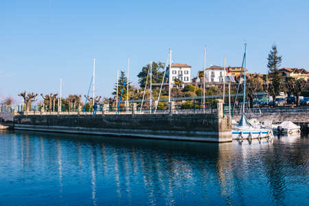 Port of sailboats with traditional and tourist village, Ranco, Lombardy, Lago Maggiore, Italy