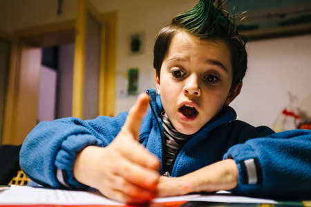 portrait of 9 year old boy at home with crest of green colored hairの写真素材