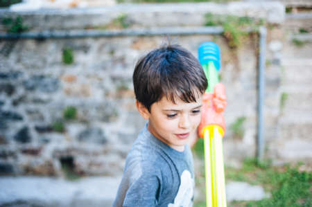children play in the garden with guns and water rifles on a sunny summer day having a lot of funの写真素材
