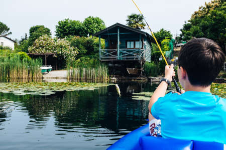 12 year old boy fishing in canoe on Lake Monate
