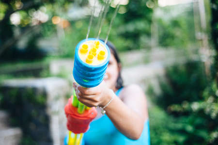 children play in the garden with guns and water rifles on a sunny summer day having a lot of funの写真素材