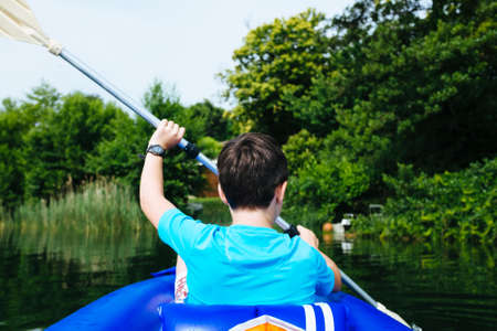 12 year old boy lying in canoe on Lake Monateの写真素材