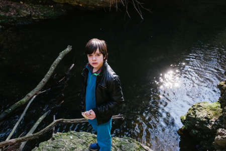 12 year old boy eating sandwich outside in natureの写真素材