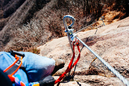 mountaineer as he climbs mountain, along a via ferrata in the autumnの写真素材