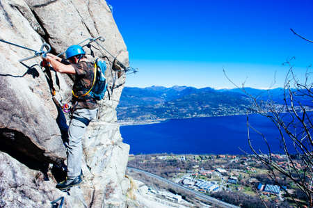 mountaineer as he climbs mountain, along a via ferrata in the autumnのeditorial素材