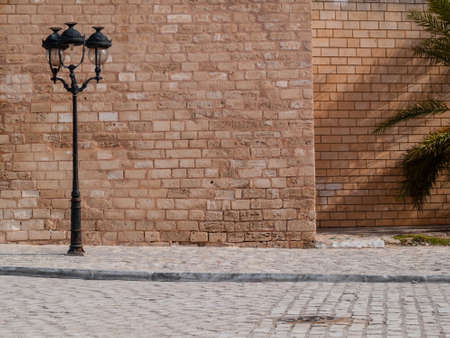 Mahdia Tunisia exterior wall of the Great Mosque, brick wall with three-light street lampの写真素材