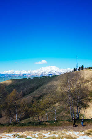 Meadows and hills in spring, in the background the Alpine chain, Piedmont Italyの写真素材