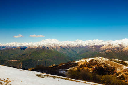 Meadows and hills in spring, in the background the Alpine chain, Piedmont Italyの写真素材