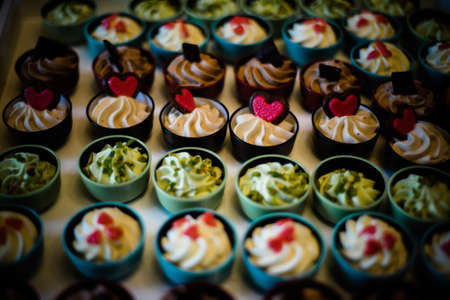 cup cakes of various sweets over tray in wedding partyの写真素材