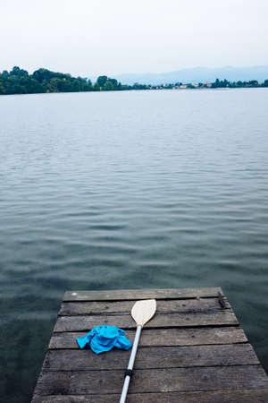 Lake of Monate,wooden pier with paddle and T-shirt placed on topの写真素材