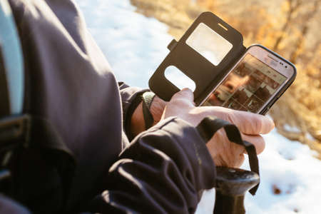 hiker uses application on smartphone during hike