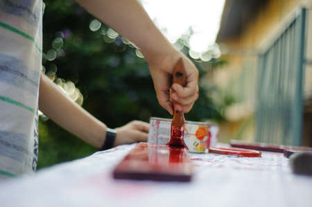 child painting of red wooden planks in his gardenの写真素材