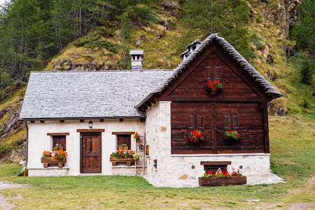mountain house with flowers on the windows in the nature,Alpe Devero,Italyの写真素材