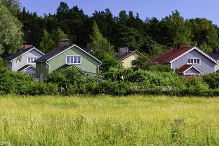 Colorful wooden homes nestled among lots of greenery in a suburb of Turku, Finland.の写真素材
