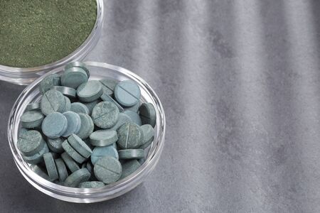 Spirulina powder and pills in the bowl - Spirulina