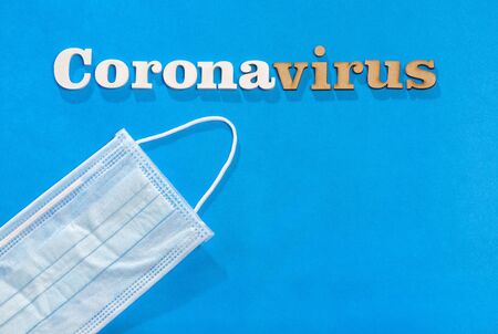 Coronavirus phrase text on a blue background with protective mask.の写真素材