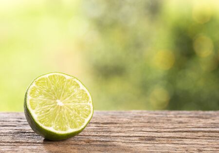 Citrus Ã latifolia - Tahiti lemon. Wooden table in the park among the trees on a summer day.の写真素材