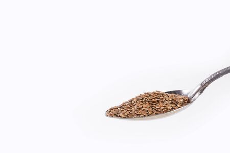 Organic seeds of flaxseed in the spoon - Linum usitatissimumの写真素材