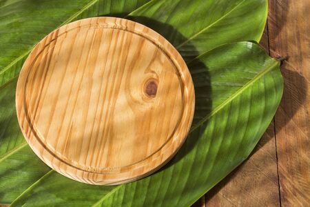 Round chopping board on bijao sheets - Calathea lutea