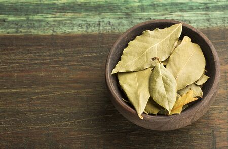 Dried bay leaves - Laurus nobilis. Wood background