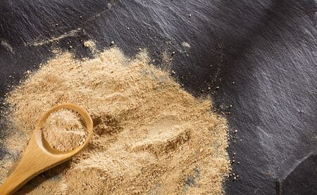 Maca powder in wooden spoon - Lepidium meyenii.