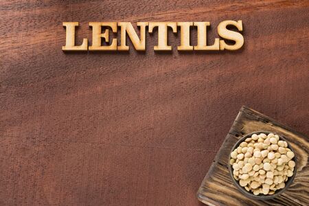 Raw lentils in the bowl - Lens culinaris. Wooden backgroundの写真素材