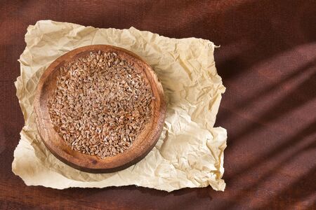 Organic linseed seeds in the wooden bowl - Linum usitatissimumの写真素材