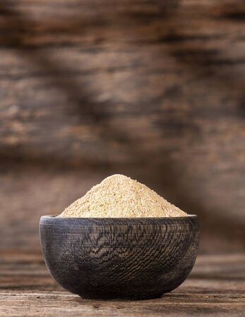 Organic maca root powder in wooden bowl - Lepidium meyeniiの写真素材