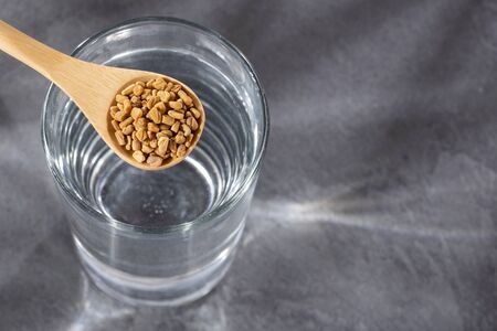 Spoon with fenugreek grains to mix with water - Trigonella foenum-graecumの写真素材