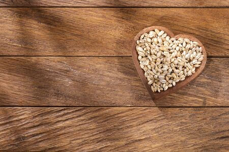 Pearl barley in the heart shaped bowl - Hordeum vulgareの写真素材