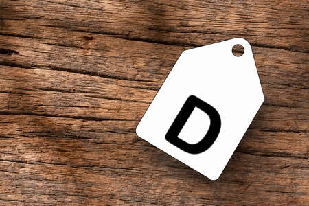 Letter Q on white label on wooden backgroundの写真素材