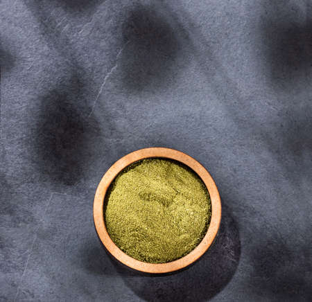 Organic green powder in the wooden bowl - text spaceの写真素材