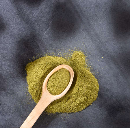 Organic green powder on wooden spoon - text spaceの写真素材