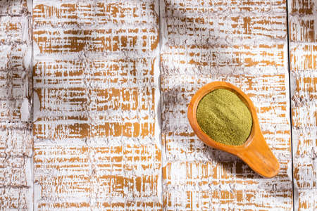 Organic green powder on wooden spoon - text spaceの写真素材