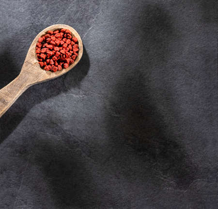 Bixa Orellana - Organic achiote seeds in wooden spoonの写真素材