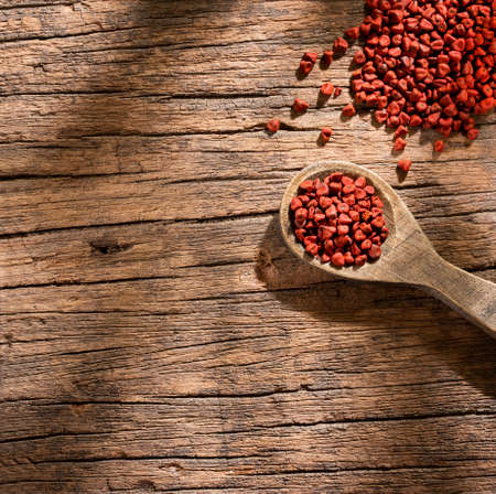 Organic achiote seeds in wooden spoon - Bixa Orellanaの写真素材