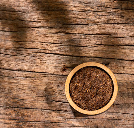 Black tea powder in wooden bowl - Camellia sinensisの写真素材