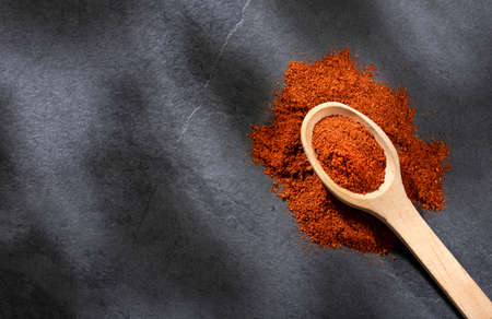 Organic paprika powder in wooden spoon - Text spaceの写真素材