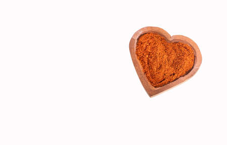 Organic red paprika powder in heart shaped bowl - Capsicum annuumの写真素材