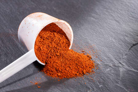 Organic paprika powder in spoon - Capsicum annuum