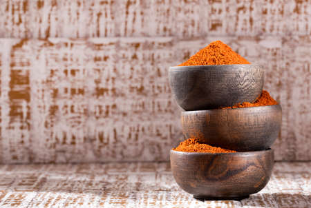 Paprika powder in three wooden bowls - Capsicum annuum