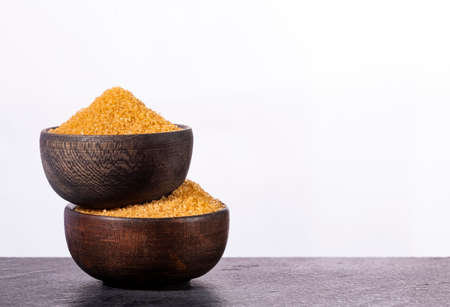Organic brown sugar in two wooden bowls - Saccharum officinarumの写真素材