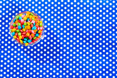 Mini colored chewing gums in the bowl - Text space