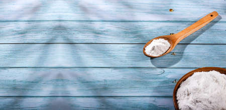 Baking soda in glass bowl and wooden spoon