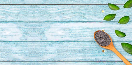 Organic poppy seeds in wooden spoon - Papaver somniferumの写真素材