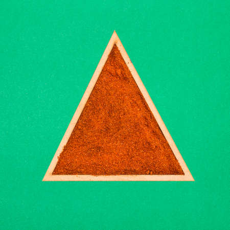 Paprika powder in a triangular bowl - Capsicum annuumの写真素材